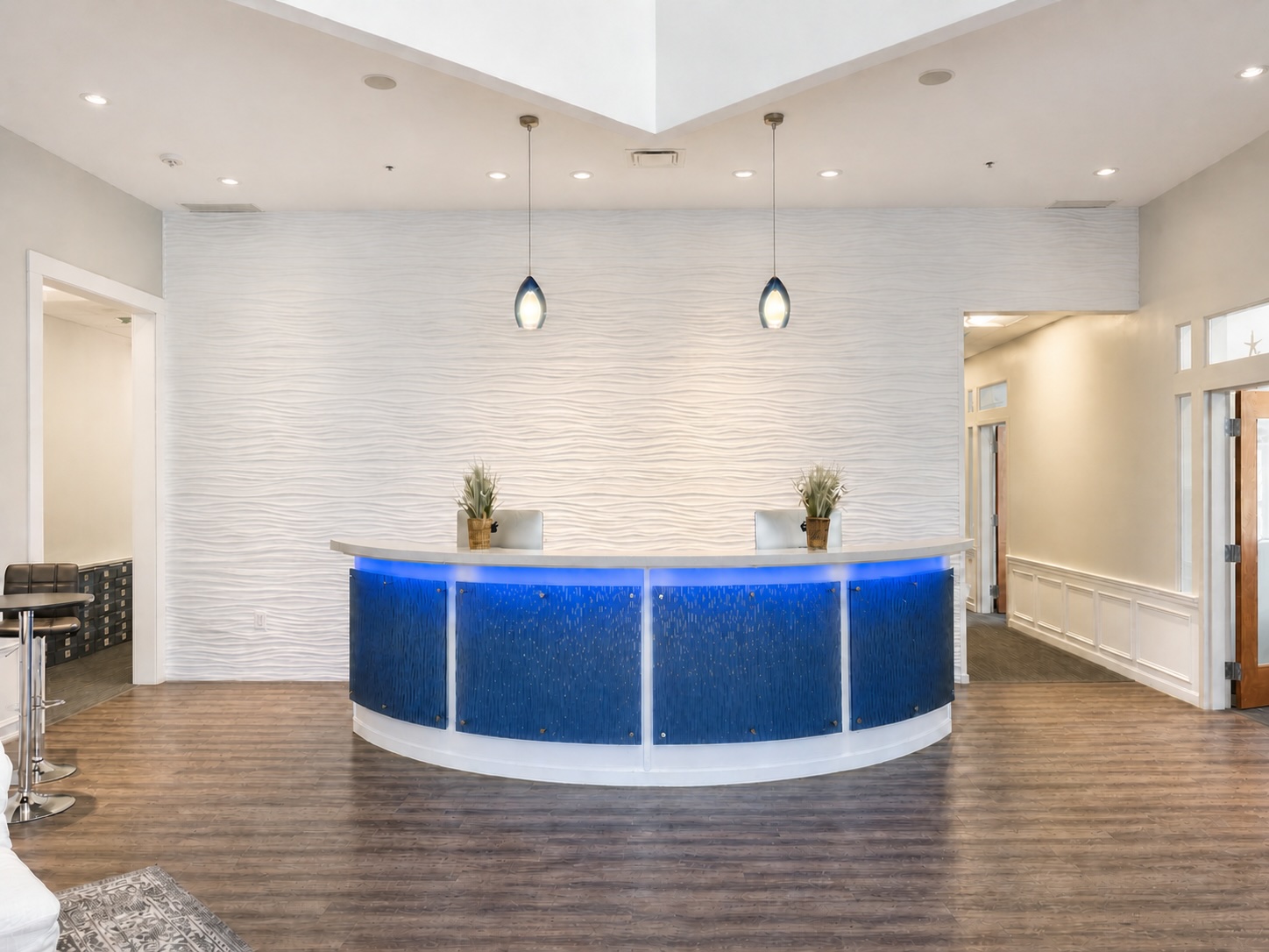 Reception desk with blue accent lighting and a textured white feature wall, where virtual office mail is received